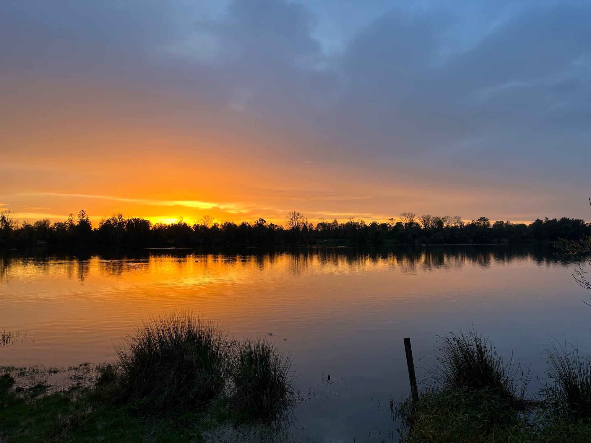 Ein sich im See spiegelnder goldener Sonnenuntergang